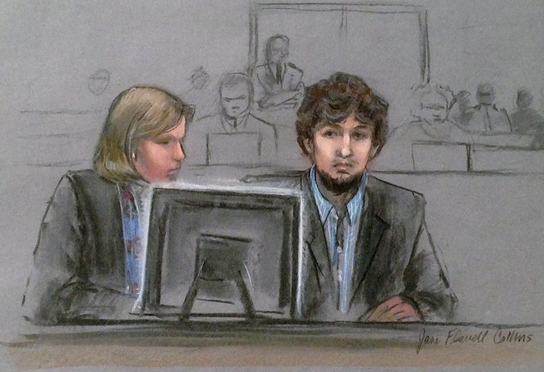 Dzhokhar Tsarnaev, right, and defense attorney Judy Clarke are depicted watching evidence displayed on a monitor during his federal death penalty trial Monday, March 9, 2015, in Boston. Tsarnaev is charged with conspiring with his brother to place two bombs near the marathon finish line in April 2013, killing three and injuring 260 spectators. (AP Photo/Jane Flavell Collins)