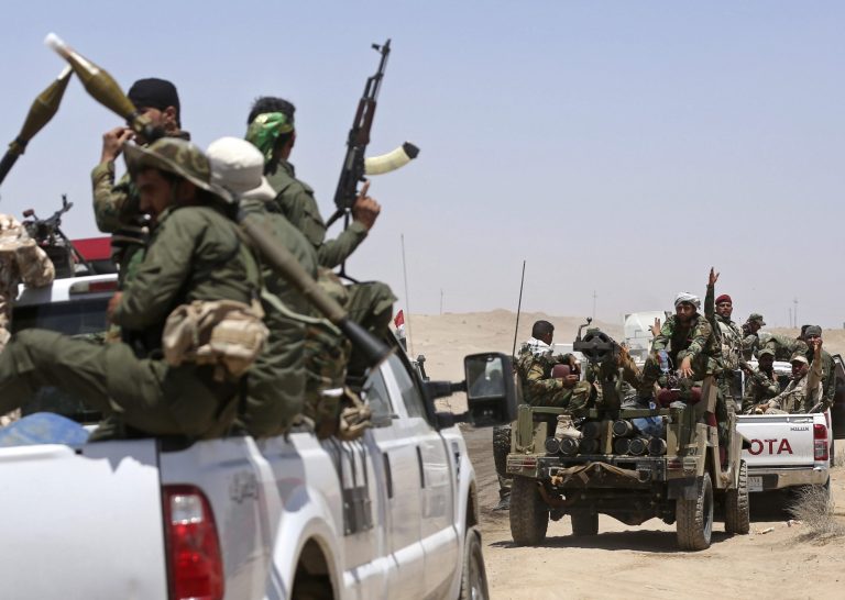 In this Friday, June 12, 2015 photo, fighters from the Shiite Badr Brigades militia patrol at the front line, in Kessarrat, (70 kilometers) northwest of Baghdad, Iraq. (AP Photo/Hadi Mizban)