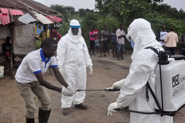 Health workers wash their hands after taking a blood specimen from a child to test for the Ebola virus in an area where a 17-year old boy died from the virus on the outskirts of Monrovia, Liberia, Tuesday, June 30, 2015. Liberian authorities on Tuesday quarantined the area where the corpse of the boy was found, sparking fears this West African country could face another outbreak of the disease nearly two months after being declared Ebola-free. (AP Photo/ Abbas Dulleh)