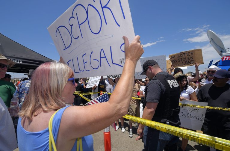 A demonstrator that opposes illegal immigration, left, shouts at immigration supporters, Friday, July 4, 2014, outside a U.S. Border Patrol station in Murrieta, Calif. The Library of Congress has decided to stop using the term 