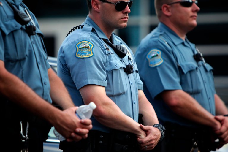 Police officers wear what appear to be body cameras as they hold the line against protesters gathered at the police station during a rally in Ferguson, Mo. on Saturday for Michael Brown. (AP/St. Louis Post-Dispatch, Huy Mach)
