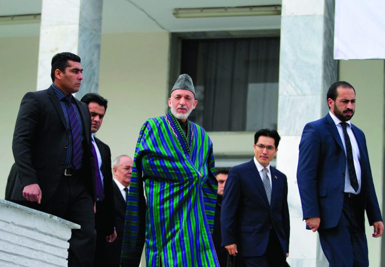 Afghan President Hamid Karzai, center, arrives for a group photo for an ambassadors and consuls general conference in Kabul, Afghanistan, Saturday, Dec. 15, 2012. Afghan President Hamid Karzai said Saturday that the U.S. and NATO troops transferring security to Afghan forces should leave Afghan villages as soon as possible and pull back to their bases. (AP Photo/Ahmad Jamshid)