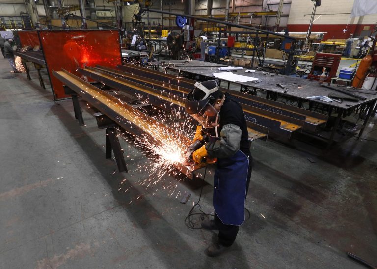 In this Thursday, Jan. 23, 2014 photo, Jesus Rodriguez grinds steel at the IDEAL Group in Detroit. The Institute for Supply Management reports on U.S. manufacturing activity in February on Monday, March 3, 2014.  (AP Photo/Paul Sancya)