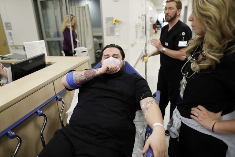 Donnie Cardenas recovers from the flu at the Palomar Medical Center in Escondido, Calif. The San Diego County resident said he was battling a heavy cough for days before a spike in his temperature sent him into the emergency room on Jan. 10. (AP Photo/Gregory Bull)
