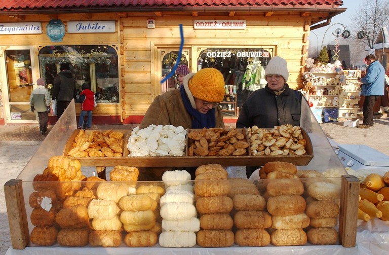   FILE - This is a Jan. 14, 2006 file photo of a street vendor selling regional smoked cheese 'oscypek ' in Zakopane, Poland. Little Miss Muffet could have been separating her curds and whey from the sixth millennium B.C., according to a new study that finds the earliest solid evidence of cheese-making. Scientists performed a chemical analysis on fragments from 34 pottery sieves discovered in Poland to determine what they were used for. Until now, experts weren't sure whether such sieves were used to make cheese, beer or honey. (AP Photo/Czarek Sokolowski, File)  