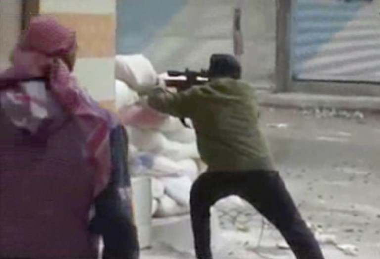   This image from amateur video AP obtained from Ugarit News has been authenticated based on its contents and other AP reporting and shows a rebel firing a weapon around a corner at Syrian government forces in Damascus, Syria Friday Dec. 7, 2012. Fighting around the Syrian capital has intensified in recent days as rebels press a battle they hope will lead to the collapse of President Bashar Assad's regime after 20 months of conflict. (AP Photo/Ugarit News via AP Video)  