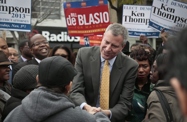 Democratic mayoral candidate Bill de Blasio, center, accompanied by Ken Thompson, fifth from right, candidate for Brooklyn district attorney, meet potential voters on Tuesday, Nov. 5, 2013, in the Crown Heights section of New York's borough of Brooklyn.  De Blasio, 52, seems poised to become the first Democrat elected mayor in more than a generation, replacing Michael Bloomberg who helmed the nation's biggest city for 12 years.  (AP Photo/Bebeto Matthews)