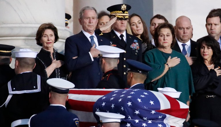 Former President George W. Bush, Laura Bush, left, and other family members watch as the flag-draped casket of former President George H.W. Bush is carried by a joint services military honor guard to lie in state in the rotunda of the U.S. Capitol, Monday, Dec. 3, 2018, in Washington. 