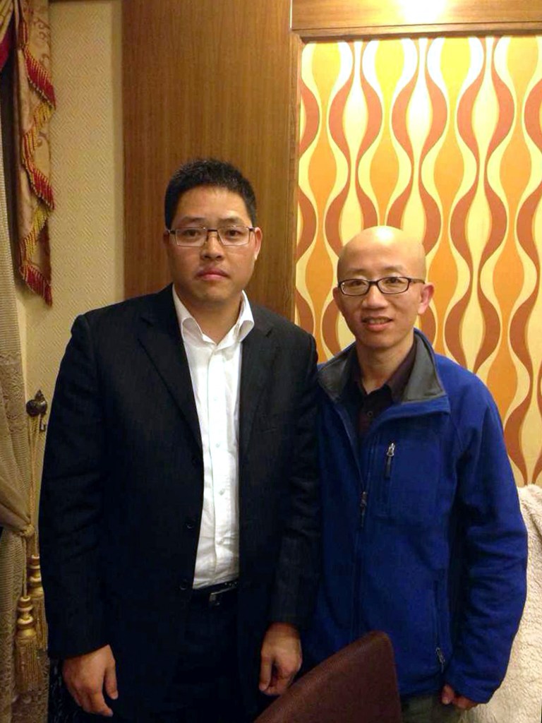 FILE - In this file photo taken in early 2014 and released by the family of Wang Aizhong, left, Wang, a leading figure of a small citizen movement in southern China, poses for photos with Chinese activists Hu Jia in Guangzhou in south China's Guangdong province. Wang, who has been a key figure of the amorphous Southern Street Movement that seeks an end to China's one-party rule and urges its followers to take to the street to make their appeals public, was released on bail on Wednesday, June 25, nearly one month after he was taken into police custody, his lawyers said. (AP Photo/Family of Wang Aizhong, File)