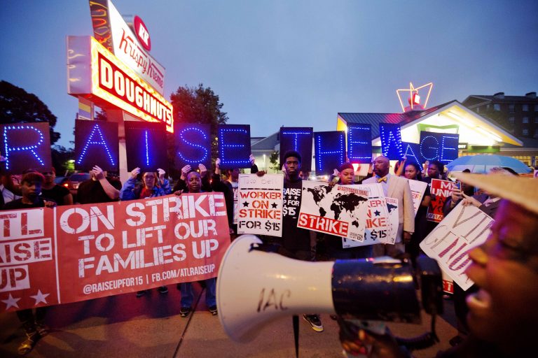 McDonald's employee Connie Ogletree, 55, right, leads a group of fast food workers and supporters in a chant during a protest outside a Krispy Kreme store, Thursday, May 15, 2014, in Atlanta. Calling for higher pay and the right to form a union without retaliation, fast-food chain workers in Atlanta protested Thursday as part of a wave of strikes and protests in 150 cities across the U.S. and 33 additional countries on six continents.  (AP Photo/David Goldman)