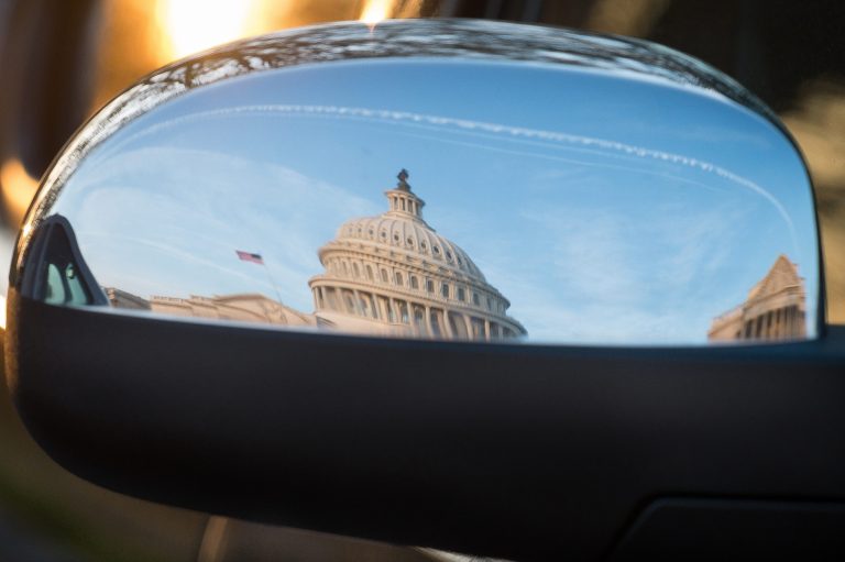 The U.S. Capitol Dome is reflected in the rear view mirror of a security vehicle in Washington. (AP Photo/J. David Ake)