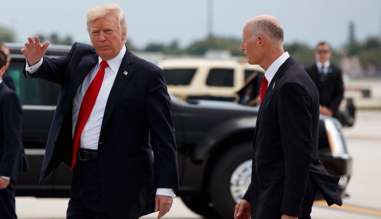President Donald Trump, followed by Florida Gov. Rick Scott, waves upon his arrival on Air Force One at Miami International Airport in Miami, Friday, June 16, 2017, before giving a speech on Cuba policy. (AP Photo/Evan Vucci)