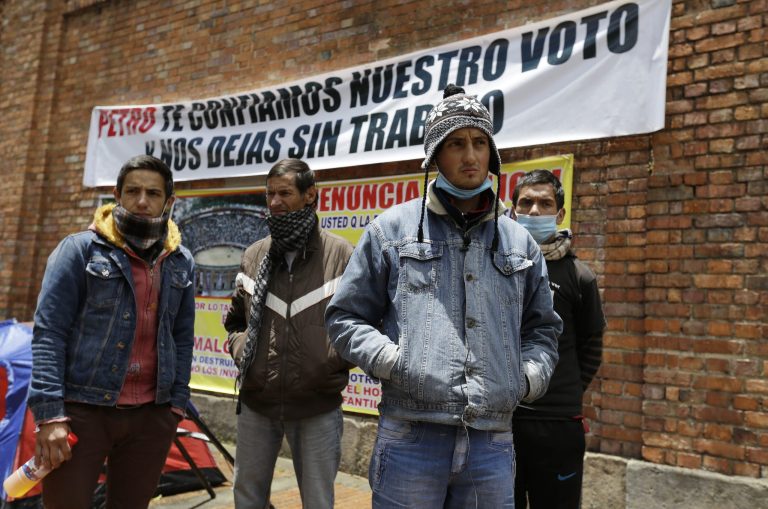 FILE - In this Aug. 13, 2014, file photo, Colombian bullfighters Omar Rodriguez, left, Alfredo Pena, second left, Diego Torres, second right, and David Rodriguez, right, stand outside La Santa Maria bullring while staging a hunger strike in Bogota, Colombia. Eight bullfighters have been striking for more than a week in tents outside the city's only bullring after Mayor Gustavo Petro ended bullfighting in the city when he cancelled the bullring's lease in June 2012. He said he wanted public places to be used for activities of 