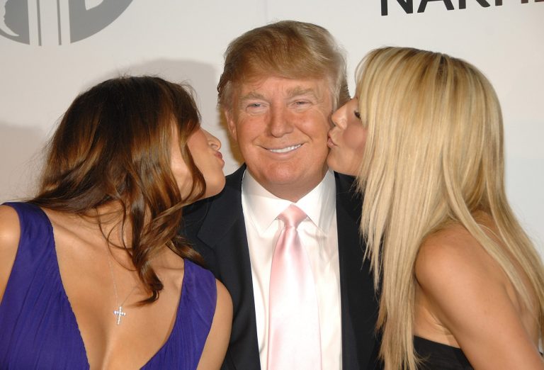 Real estate tycoon Donald Trump, center, gets kisses from his wife Melania, left, and model Heidi Klum at a party in 2008 in New York. (AP Photo/Evan Agostini)