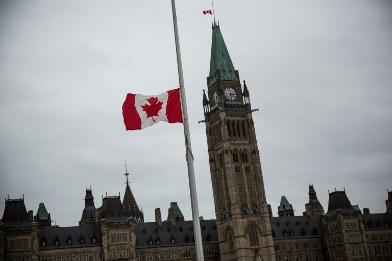 A flag next to the Canadian Parliament Building is flown at half staff one day after Cpl. Nathan Cirillo of the Canadian Army Reserves was killed while standing guard in front of the National War Memorial by a lone gunman, on October 23, 2014 in Ottawa, Canada. (Photo by Andrew Burton/Getty Images)