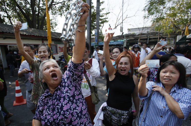 Voters hold their identification cards and the chains that held the gate of the polling station closed, as they demand the right to vote during general elections in Bangkok, Thailand, Sunday, Feb. 2, 2014. Around the country, the vast majority of voting stations were open and polling proceeded relatively peacefully, but the risk of violence remained high a day after gun battles in Bangkok left seven people wounded. (AP Photo/Wally Santana)