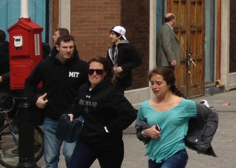 This Monday, April 15, 2013, shows a man who was dubbed Suspect No. 2 in the Boston Marathon bombings by law enforcement, in the upper center of the frame, wearing a white baseball cap, walking away from the scene of the explosions. The FBI identified him as 19-year-old college student Dzhokhar Tsarnaev, who along with his brother Tamerlan, 26, previously known as Suspect No. 1, killed an MIT police officer, severely wounded another lawman and hurled explosives at police in a car chase and gun battle during a night of violence. (AP Photo/David Green)
