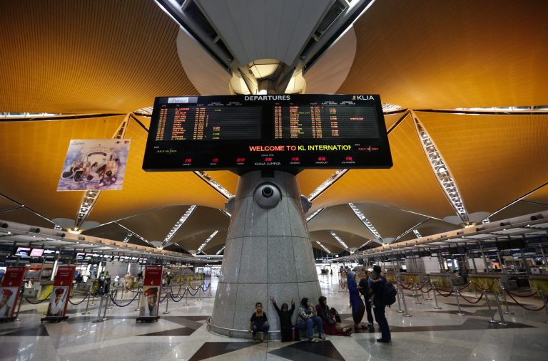 Passenger wait at the departure hall at Kuala Lumpur International Airport, in Sepang, Malaysia, Friday, July 18, 2014.  Malaysia Airlines said it lost contact with Flight MH17 over Ukrainian airspace Thursday. It was flying from Amsterdam to Kuala Lumpur, Malaysia. (AP Photo/Vincent Thian)