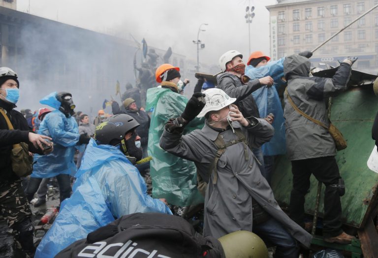 Anti-government protesters throw stones during clashes with riot police in Kiev's Independence Square, the epicenter of the country's current unrest, in Ukraine on Feb. 19. The deadly clashes in Ukraine's capital have drawn sharp reactions from Washington, generated talk of possible European Union sanctions and led to a Kremlin statement blaming Europe and the West. (AP Photo/Efrem Lukatsky)