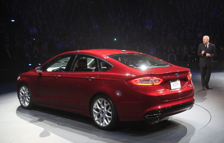   FILE - In this Monday, Jan. 9, 2012, file photo, Derrick Kuzak, Ford group vice president, introduces the 2013 Ford Fusion during the North American International Auto Show in Detroit. Ford said on Monday, Dec. 10, 2012, it will update software on 2013 Escape SUVs and Fusion cars to fix a coolant problem that can cause fires. Last month the automaker recalled more than 89,000 of the vehicles after getting complaints about overheating and fires. It urged owners to get loaner cars from dealers until Ford found a fix.(AP Photo/Carlos Osorio, File)  