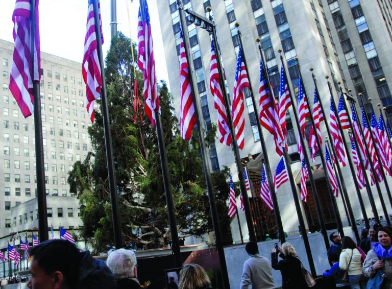 FILE - This Nov. 14, 2012 file photo shows the 80th Rockefeller Center Christmas Tree being raised in New York's Rockefeller Center. The 80-foot Norway Spruce, donated by Joseph Balku, of Flanders, N.J., will be strung with 30,000 multi-colored, LEDs on 5 miles of wire, and topped with a Swarovski Crystal Star. The tree is scheduled to be lit during ceremonies Wednesday Nov. 28. Nearly all the city's major attractions _ with a few exceptions like the Statue of Liberty and Ellis Island _ have reopened following Superstorm Sandy and officials expect the rest of the year to be a busy one for the tourism industry. (AP Photo/Richard Drew, file)