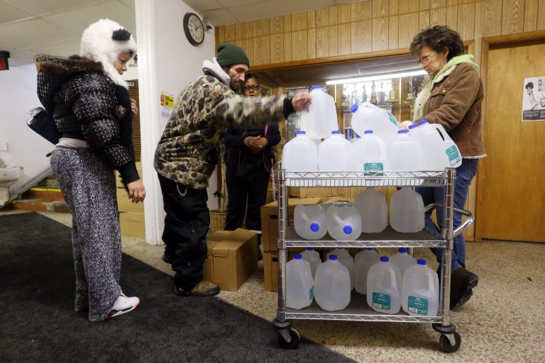 In this Feb. 3, 2015 photo, Flint residents receive free water being distributed at the Lincoln Park United Methodist Church in Flint, Mich.Â Bottles of water are being donated from businesses and nonprofits around the state.Â (AP Photo/Paul Sancya)