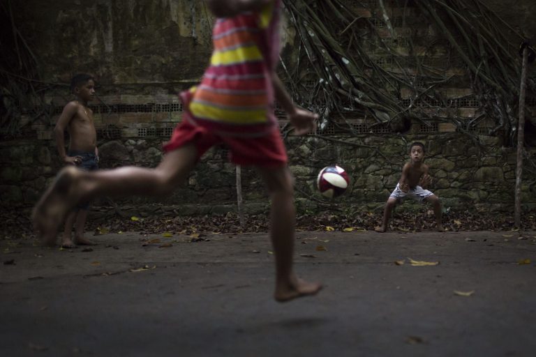 In this May 21, 2014 photo, A boy kicks a penalty during a soccer match in the ruins of Paricatuba, near Manaus, Brazil. Children of the tiny village of Paricatuba, which grew up around the villa, use the ruins as a spot for energetic games of barefoot soccer or to scare themselves silly. Teenagers come here to make out, and older people to get drunk. (AP Photo/Felipe Dana)