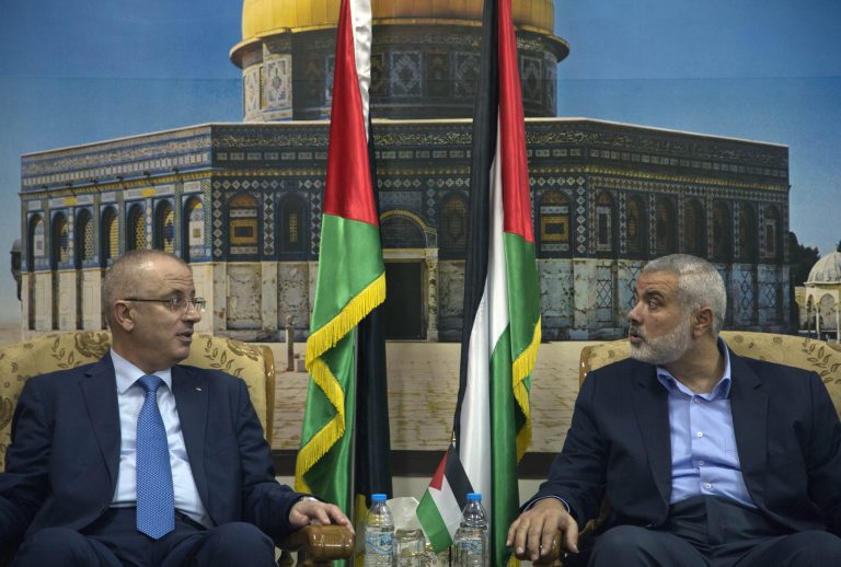 Palestinian Prime Minister Rami Hamdallah left, meets with top Hamas leader in Gaza, Ismail Hamiyeh, right, in  Gaza City, Thursday, Oct. 9, 2014. Members of the new Palestinian unity government assembled in Gaza on Thursday for their first Cabinet session in the war-battered territory, a largely symbolic meeting meant to mark the end of absolute Hamas control of the coastal strip. (AP Photo/Khalil Hamra)