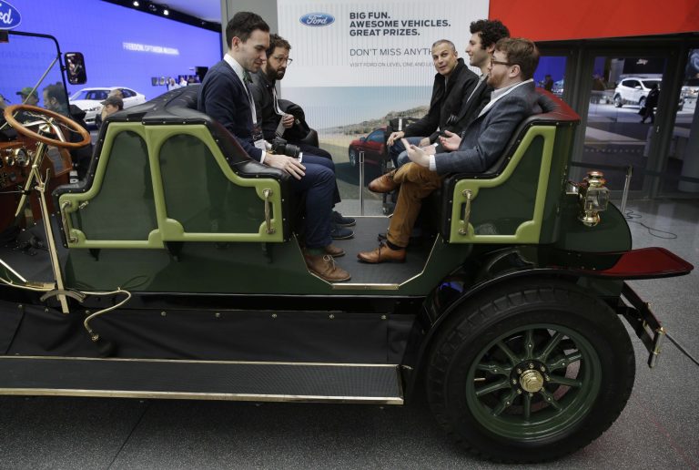 Visitors to the New York International Auto Show sit in an electric carriage prototype in New York, Thursday, April 17, 2014.  A prototype of the old-timey electric cars that Mayor Bill de Blasio would like to take the place of horse-drawn carriages on New York City streets will be unveiled at the New York Auto Show on Thursday. (AP Photo/Seth Wenig)