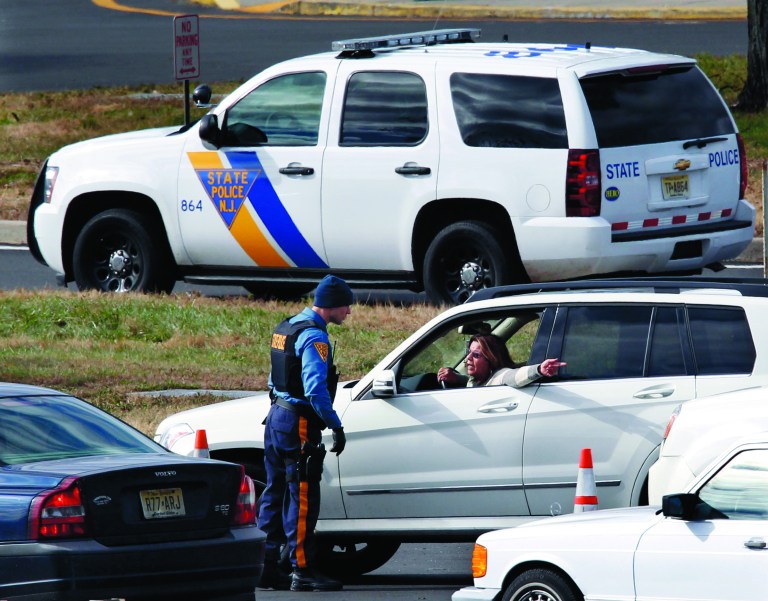 A New Jersey state trooper talks to a motorist at the Thomas A. Edison service area on the New Jersey Turnpike Saturday, Nov. 3, 2012, near Woodbridge, N.J., as troopers keep order while motorist line up to purchase gasoline. From storm-scarred New Jersey to parts of Connecticut, a widespread lack of gasoline added to the frustration since Superstorm Sandy passed through the area. Gas rationing was to starting at noon Saturday in northern New Jersey, where drivers will be allowed to buy it only every other day. (AP Photo/Mel Evans)