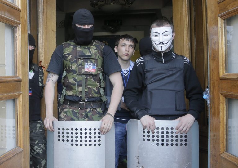 Masked pro-Russian activists guard the entrance during their mass storming of a regional Television Centre in Donetsk, Ukraine, Sunday, April 27, 2014.  Insurgents in Slovyansk have taken a number of people hostage, including journalists and pro-Ukraine activists, as they strengthen their control in the east of the country in defiance of the interim government in Kiev and its Western supporters. (AP Photo/Efrem Lukatsky)