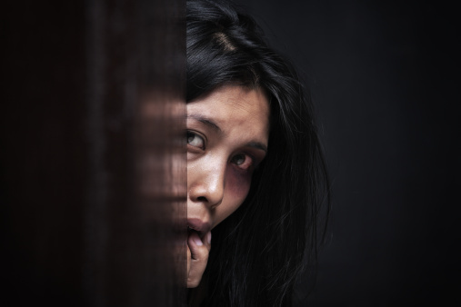 Abused woman hiding in dark
