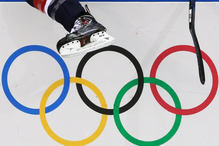A USA women's ice hockey player jumps over the boards and into bench during third period of the game against Finland at the 2014 Winter Olympics womens ice hockey match at Shayba Arena, Saturday, Feb. 8, 2014, in Sochi, Russia. (AP Photo/J. David Ake)