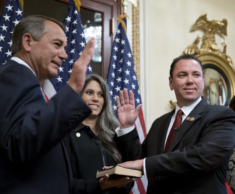 House Speaker John Boehner of Ohio, left, holds a ceremonial swearing-in for newly-elected Rep. Vance McAllister, R-La., Thursday, Nov. 21, 2013, on Capitol Hill in Washington. McAllister's wife, Kelly, watches at center. (AP Photo/J. Scott Applewhite)