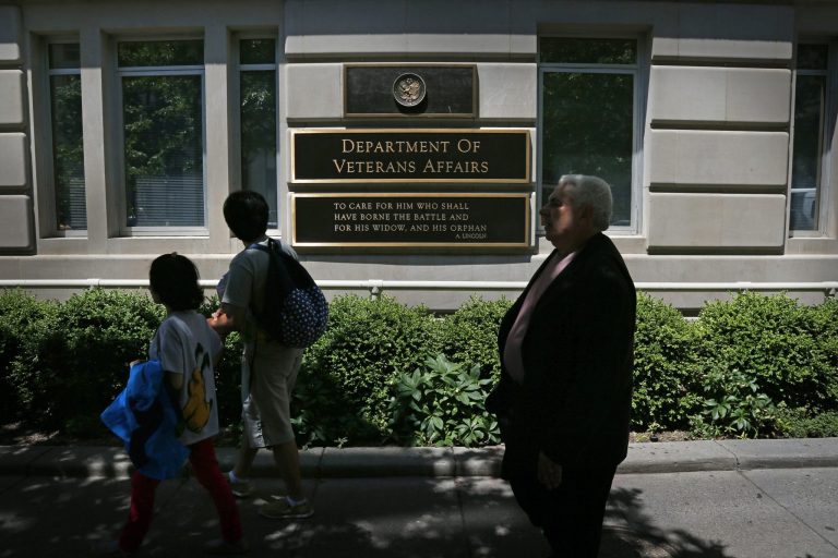 Pedestrians walk in front of the Department of Veterans Affairs building in Washington, Friday, June 21, 2013. (AP Photo/Charles Dharapak)