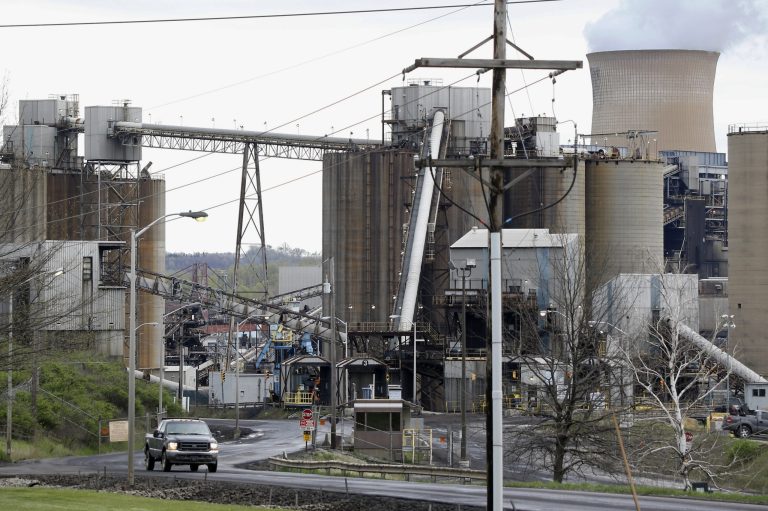 FILE - This May 5, 2014 file photo shows a pickup truck driving down a road of the Homer City Generating Station in Homer City, Pa. The Obama administration is poised to unveil first-ever rules limiting greenhouse gas emissions from the power plants that dot the U.S. map. President Barack Obama says the rules are essential to curb climate change, but critics disagree.  (AP Photo/Keith Srakocic, File)