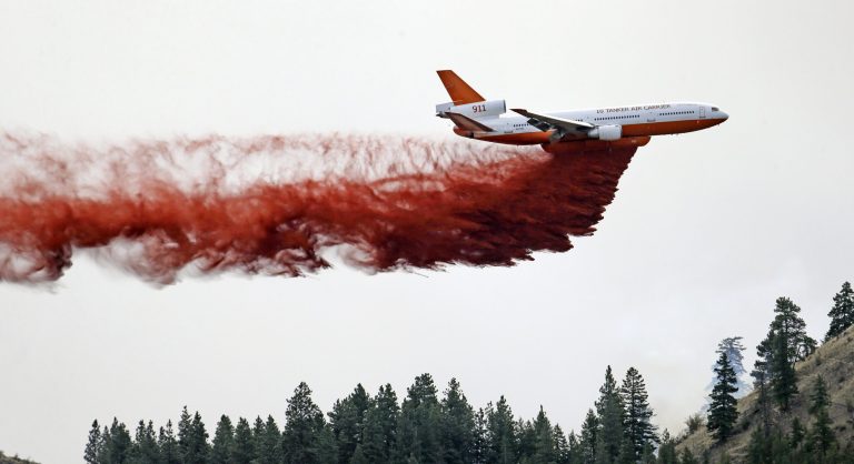 A DC-10 air tanker pulls up after dropping fire retardant over a wildfire Saturday, July 19, 2014, near Carlton, Wash. (AP Photo/Elaine Thompson)