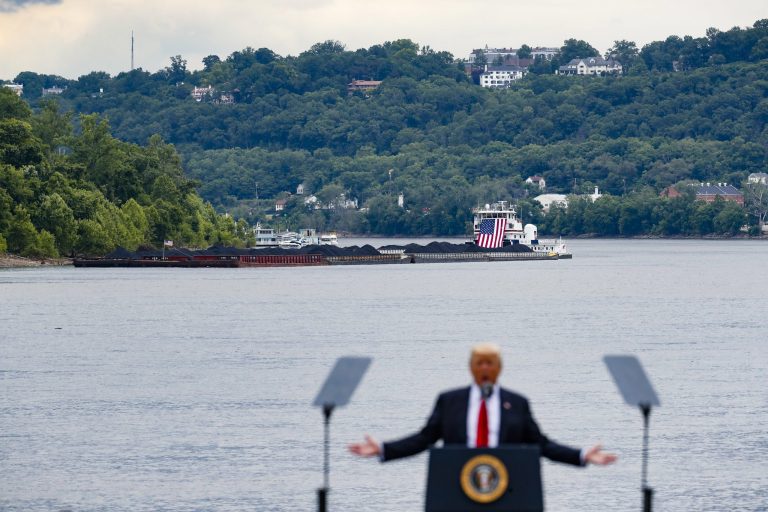 A coal barge is positioned as a backdrop behind President Trump as he speaks during at the Rivertowne Marina in Cincinnati. The Trump administration hijacked a recent United Nations climate change conference in Germany by promoting the 