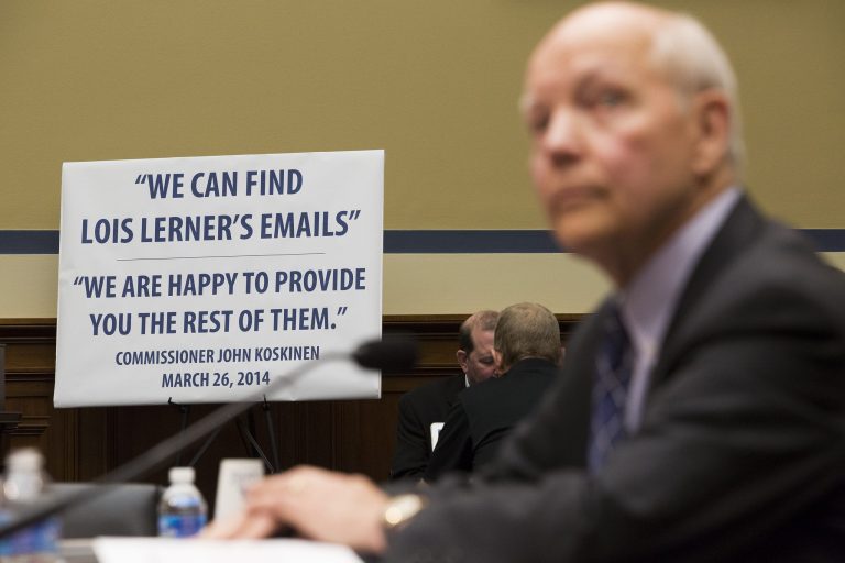 IRS Commissioner John Koskinen testifies before the House Oversight Committee as lawmakers continue their probe of whether Tea Party groups were improperly targeted for increased scrutiny by the IRS, on Capitol Hill in Washington, Monday. The sign in the background was displayed by the Republican majority staff of the committee. (Graeme Jennings/Washington Examiner)