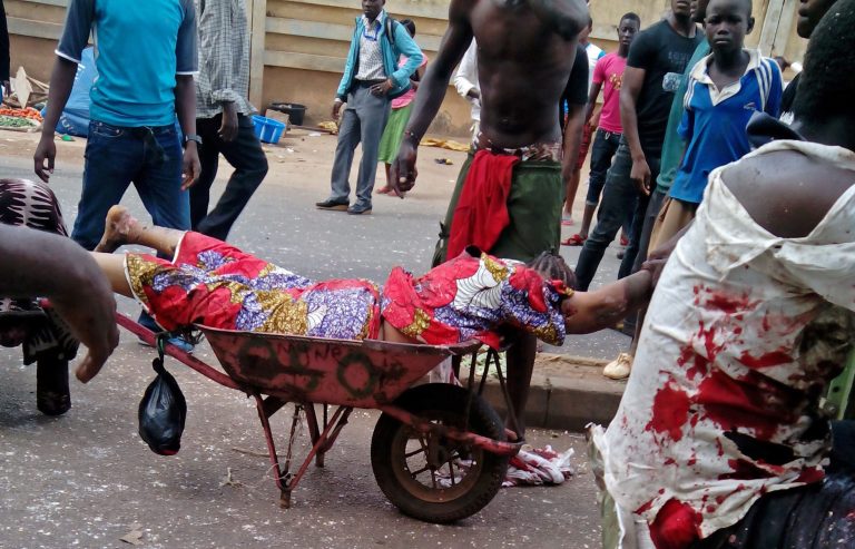 EDITORS NOTE GRAPHIC CONTENT  An injured woman is carried after bombs exploded at a bus terminal and market in Jos, Nigeria, Tuesday, May 20, 2014. Two car bombs exploded at a bustling bus terminal and market in Nigeria's central city of Jos on Tuesday, and witnesses said dozens of people were killed. No one immediately claimed responsibility for the twin car bombs, but they bore the hallmarks of Boko Haram, an Islamic extremist group. (AP Photo/Stefanos Foundation)