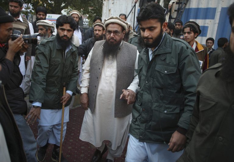 Hafiz Saeed, center, head of religious group Jamaat-ud-Dawa leaves after addressing a rally against caricatures published in French magazine Charlie Hebdo, in Lahore, Pakistan, Sunday, Jan. 18, 2015. (AP Photo/K.M. Chaudary)
