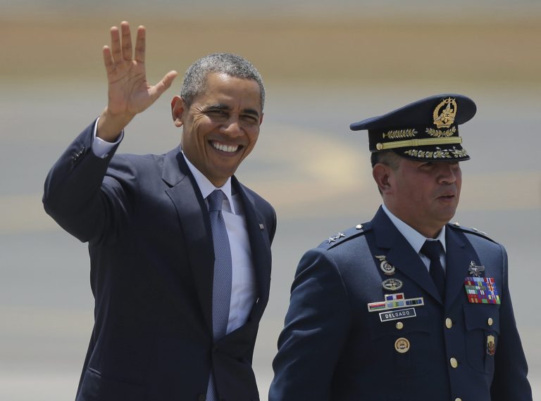 U.S. President Barack Obama, left, waves beside Philippines Air Force chief Maj. Gen. Jeffrey Delgado before boarding Air Force One as he leaves the Ninoy Aquino International Airport in Manila, Philippines Tuesday, April 29, 2014. Obama vigorously defended his foreign policy record Monday, arguing that his cautious approach to global problems has avoided the type of missteps that contributed to a 