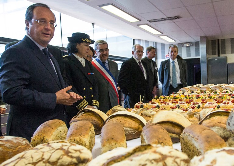 FILE - In this file photo dated Tuesday, May 6, 2014, French President Francois Hollande, left, speaks to apprentice bakers during a visit at the Institute of Artisanal Trades in Paris.  French President Francois Hollande certainly won't go hungry on upcoming Thursday night June 5, 2014, as he will host two consecutive dinners, first with U.S. President Barack Obama, then with Russian President Vladimir Putin.  Hollande will be the first Western leader to meet individually with Putin since the U.S. and EU imposed sanctions over Russia's actions in Ukraine. (AP Photo/Ian Langsdon, FILE)
