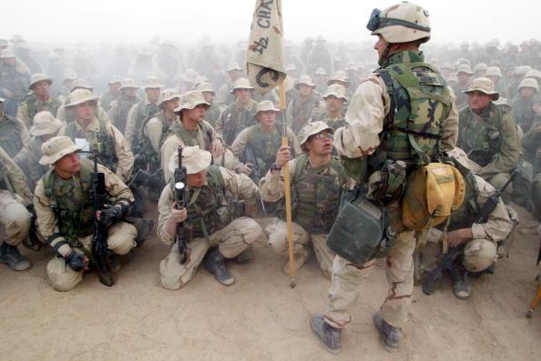 U.S. Marines of Task Force Tarawa listen to Lt. Col. Rickey Grabowski the day before they move north to invade Iraq March 19, 2003 in the northern desert of Kuwait at Camp Shoup. (Photo by Joe Raedle/Getty Images)