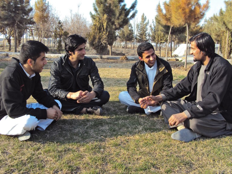 In this picture taken on Sunday, March 4, 2014, Afghan ex-translators for German military, Walid Shirzad, from left, Zamir Ahmadi, Atal Zafari and Shamsuddin Nawazish chat in a park during an interview with The Associated Press in Kunduz city, Afghanistan. According to the German government, about 950 Afghans have worked for Germany during the time its personnel have been present in Afghanistan, including drivers, translators and others. (AP Photo/Amad Yama)