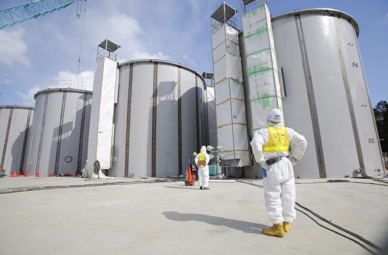 A worker looks at tanks, under construction, that store radioactive water, in the J1 area at the Tokyo Electric Power Company's tsunami-crippled nuclear plant in Okuma, Japan, on Monday. (AP Photo/Toru Hanai, Pool)