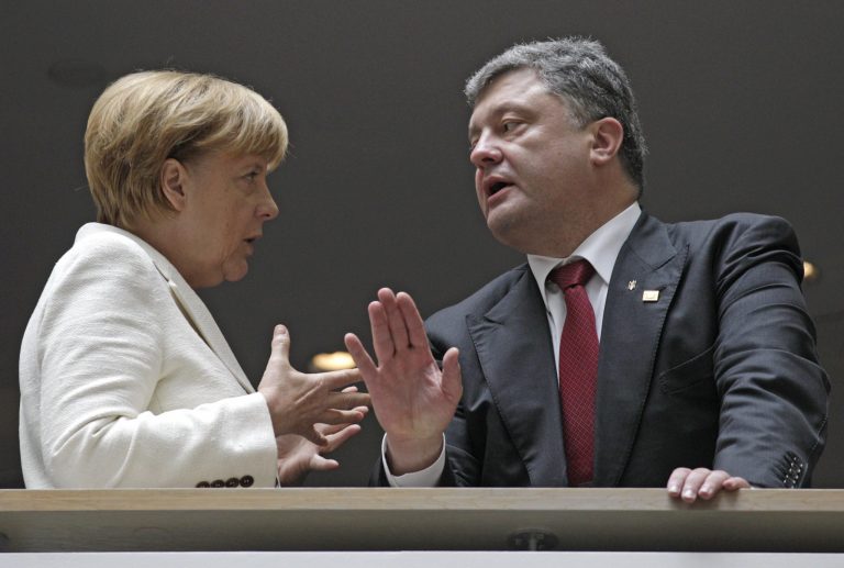 Ukrainian President Petro Poroshenko, right, talks with German Chancellor Angela Merkel during an European People's Party summit ahead of the EU summit in Brussels, Saturday, Aug. 30, 2014. EU leaders, in a one day summit, are set to decide who will get the prestigious job as the 28-nation bloc's foreign policy chief for the next five years. They will also discuss the current situation in Ukraine. (AP Photo/Yves Logghe)