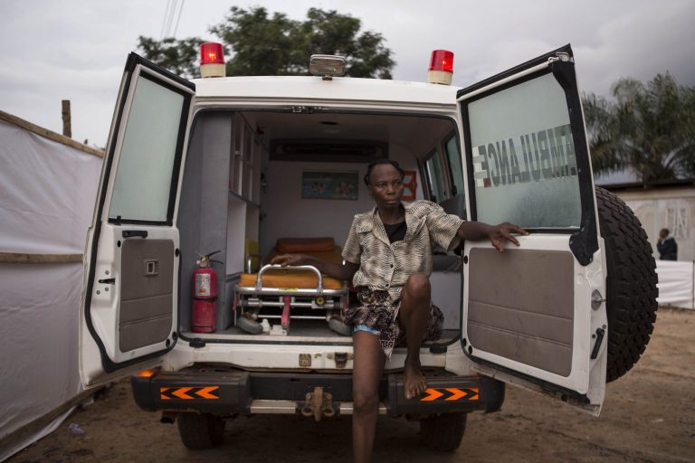 In this photo taken on Wednesday, Sept. 24, 2014, a woman suspected of suffering from the Ebola virus sits in an ambulance in Kenema, Sierra Leone. Sierra Leone restricted travel Thursday, Sept. 25, 2014 in three more 