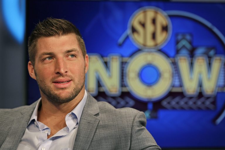 Tim Tebow ponders a question during an interview on the set of ESPN's new SEC Network in Charlotte, N.C., Wednesday, Aug. 6, 2014. Tebow has a new job as a commentator for the SEC Network, but is still looking for work in the NFL as a quarterback. (AP Photo/Chuck Burton)