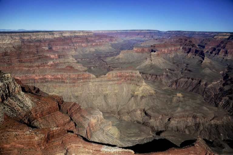 FILE - This Oct. 5, 2013 file photo, the Grand Canyon National Park is covered in the morning sunlight as seen from a helicopter near Tusayan, Ariz. An effort by the Grand Canyon to make a lucrative contract more attractive to bidders means the park will defer planned spending on new lighting, cave monitoring, building a composting toilet and tracking an endangered fish that recently reappeared in the canyon, it was announced Wednesday, Sept. 24, 2014.(AP Photo/Julie Jacobson, File)